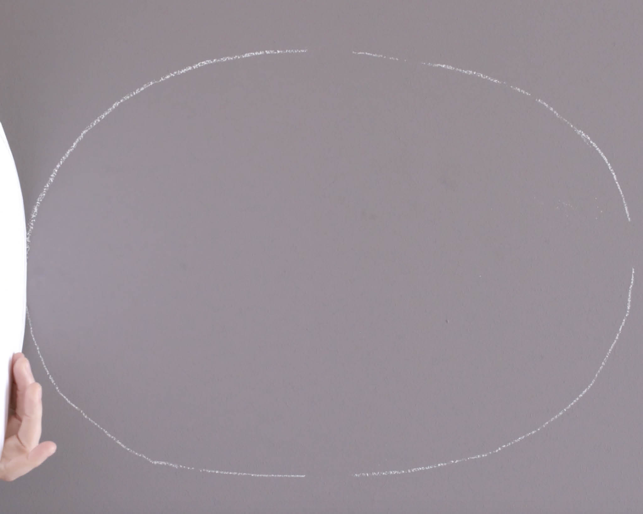 Pinta con tiza el óvalo en la pared Usa tiza para dibujar el contorno de la forma ovalada
